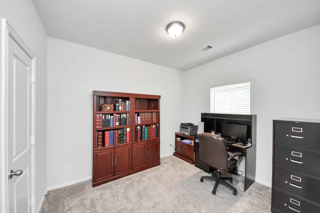 a view of a workspace with furniture and a window