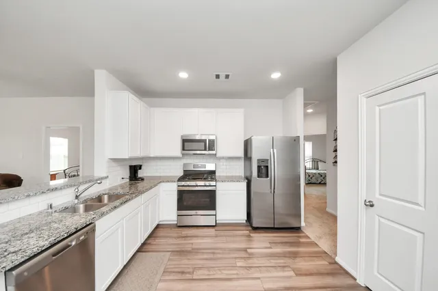 a large kitchen with a refrigerator and a sink