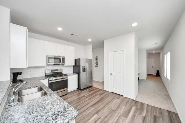 a kitchen with stainless steel appliances granite countertop a refrigerator stove microwave and sink