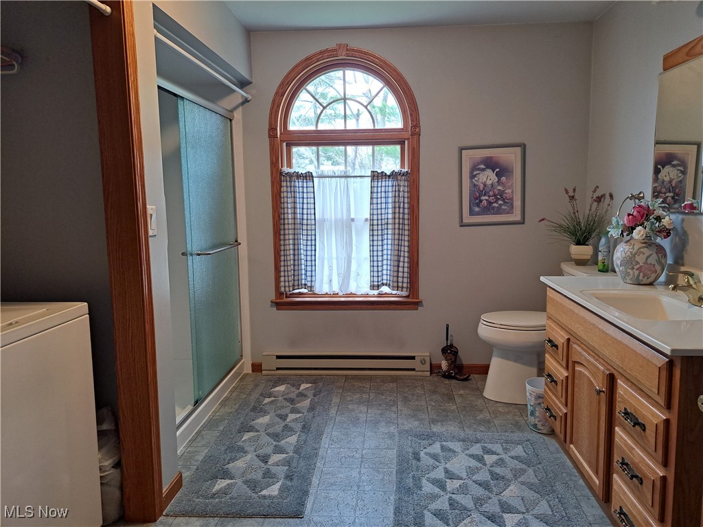 2781 Bloomfield Road Cambridge, OH 43725 - Photo 35 of 50 Bathroom featuring a baseboard heating unit, baseboards, a stall shower, toilet, and washer / dryer