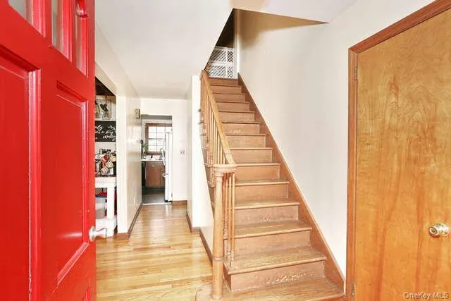 a view of a hallway with wooden floor and staircase