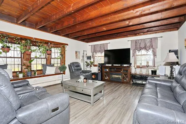 a living room with furniture a flat screen tv and a floor to ceiling window