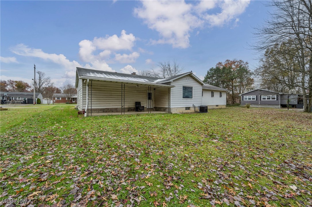 1140 Keefer Road Girard, OH 44420 - Photo 42 of 49 Back of property featuring a patio area, a lawn, and a metal roof