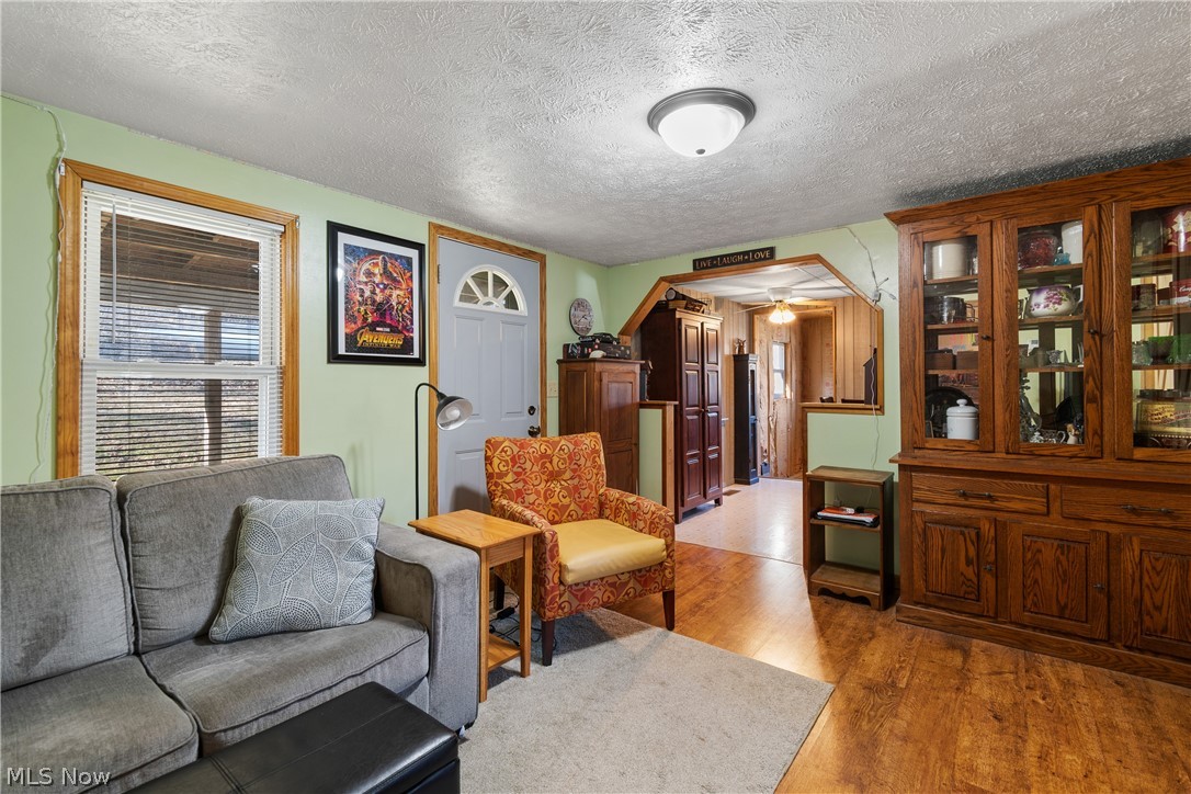 29395 Beitler Road Dennison, OH 44621 - Photo 10 of 33 Sitting room featuring a textured ceiling, light wood-style floors, a ceiling fan, and arched walkways