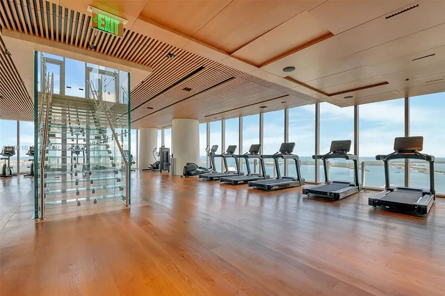 a living room with furniture large window and wooden floor