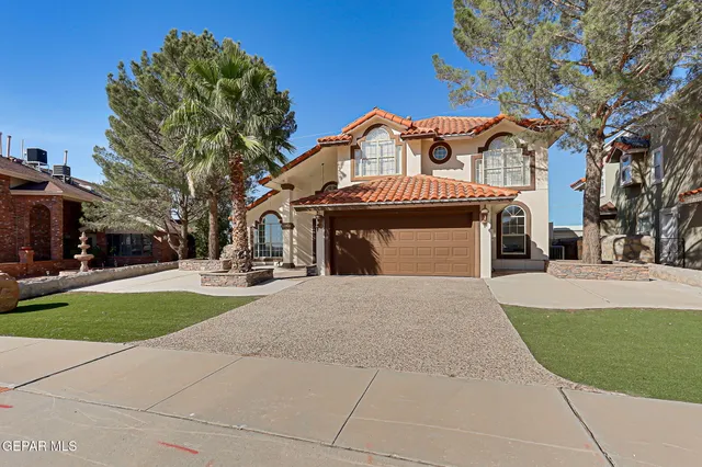 a front view of a house with a garden and tree