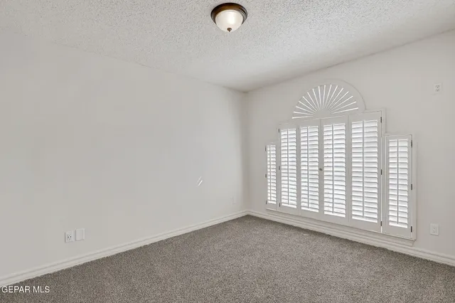 an empty room with fireplace and window
