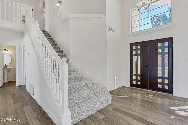 a view of a hallway with wooden floor and a living room