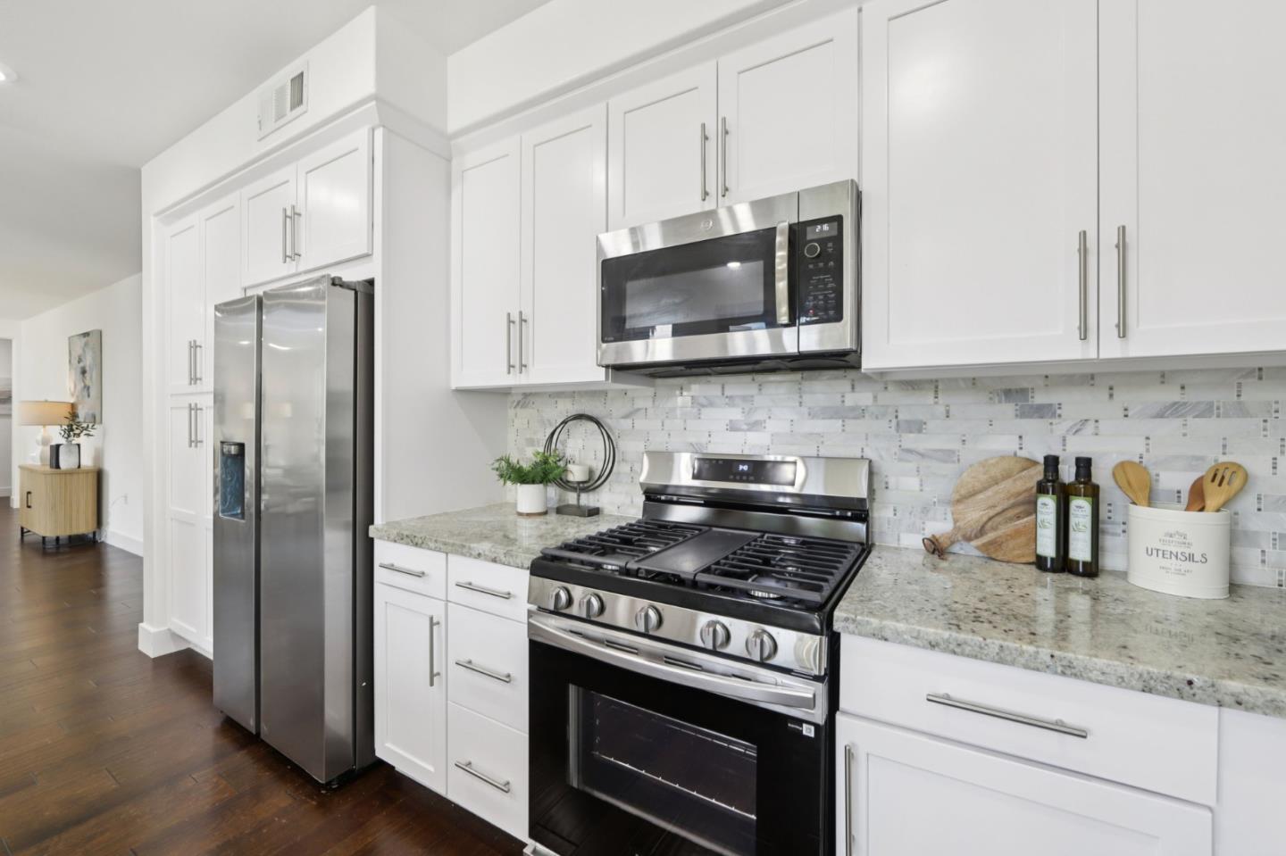 390 Riesling Avenue, Unit 21 Milpitas, CA 95035 - Photo 16 of 48 a kitchen with stainless steel appliances granite countertop a stove a refrigerator and a white cabinets
