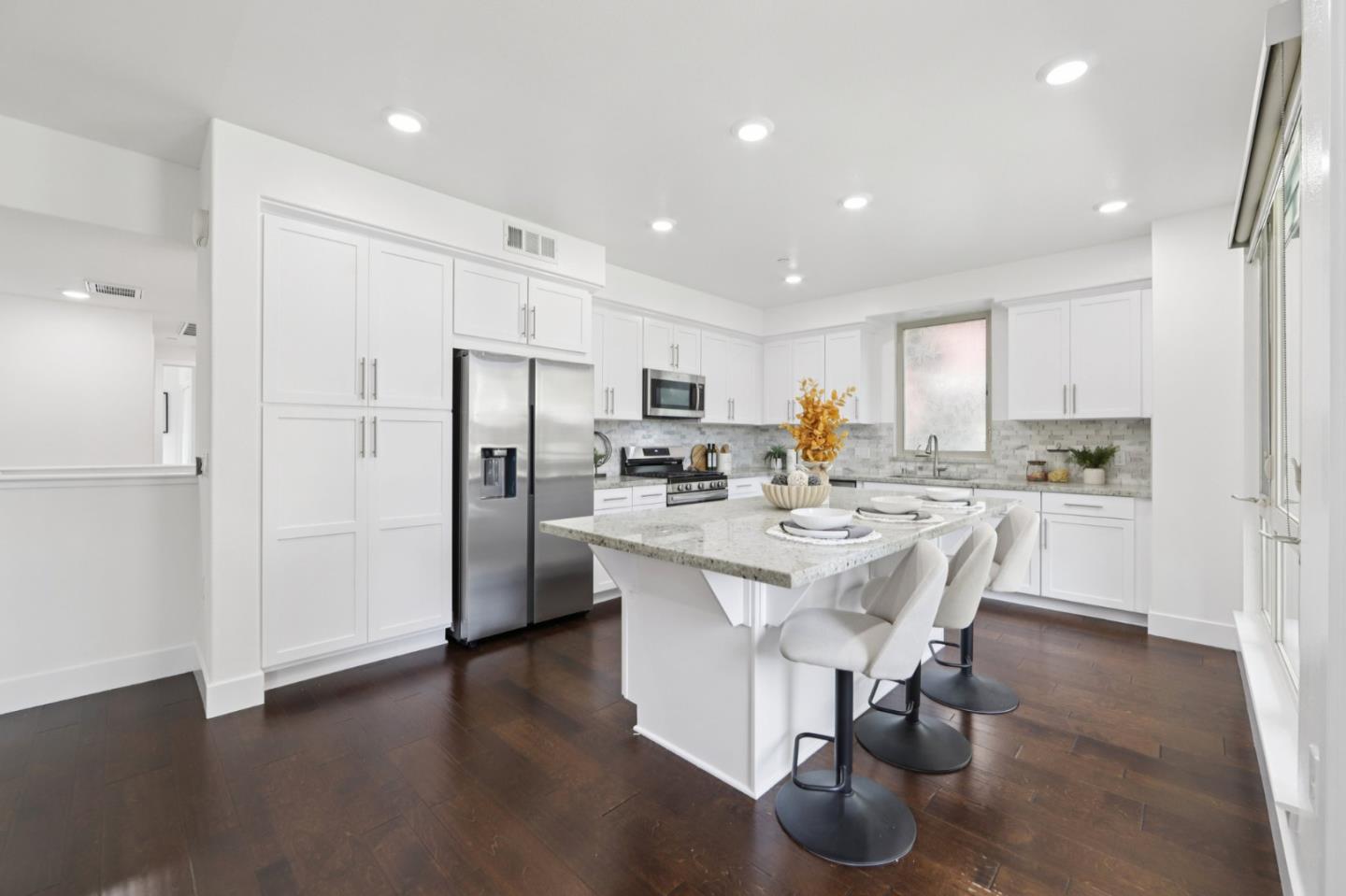 390 Riesling Avenue, Unit 21 Milpitas, CA 95035 - Photo 10 of 48 a kitchen with stainless steel appliances a dining table chairs refrigerator and microwave