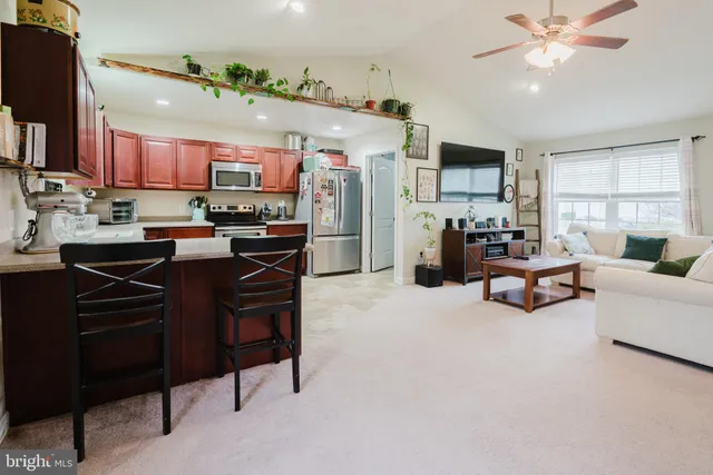 a living room with lots of furniture and kitchen view
