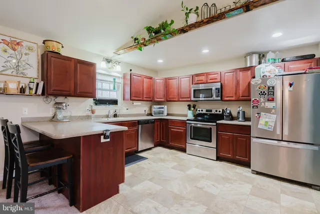 a kitchen with stainless steel appliances granite countertop a sink refrigerator and a stove