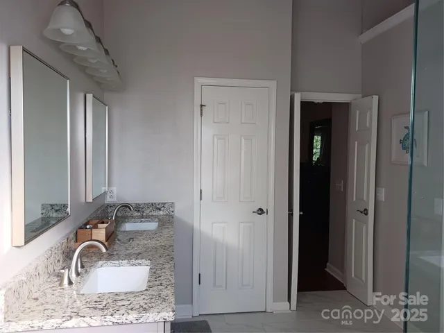 a bathroom with a granite countertop sink and a mirror