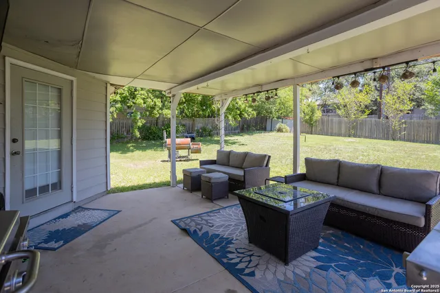 a view of a patio with couches potted plants and a big yard