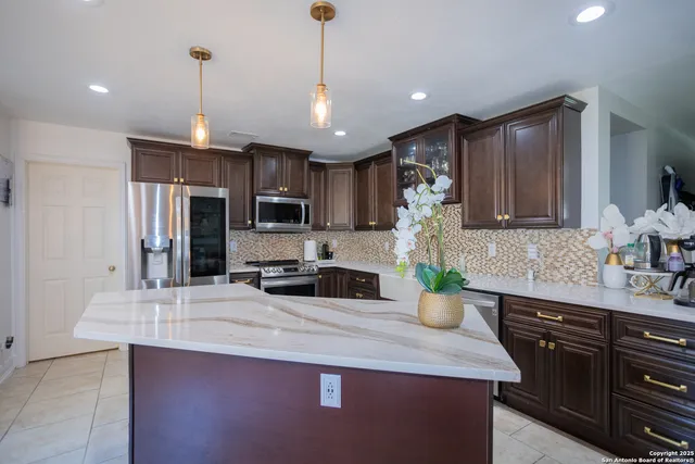 a kitchen with a refrigerator a sink and wooden cabinets