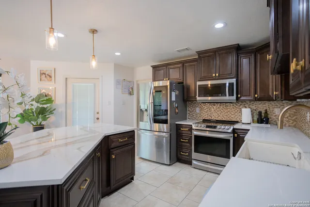 a large kitchen with stainless steel appliances granite countertop a stove a sink and a microwave