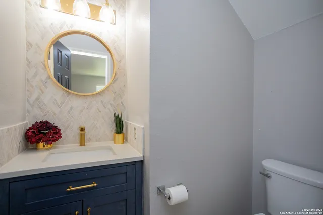 a bathroom with a sink mirror and toilet