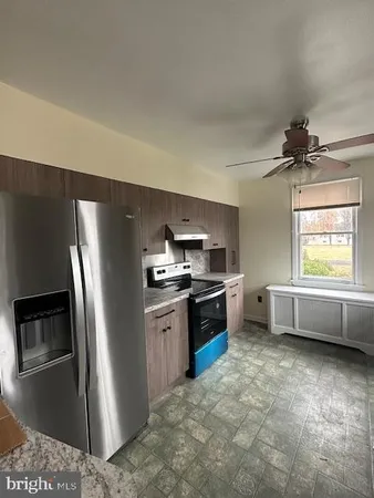 a kitchen with stainless steel appliances granite countertop a refrigerator a sink a stove and a sink