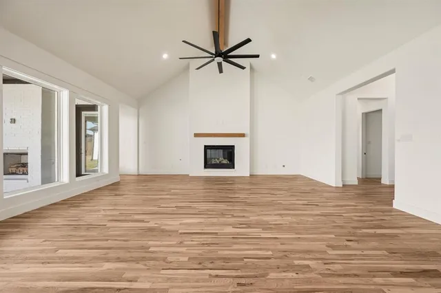 a view of an empty room with a fireplace and a window