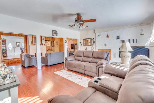 a living room with furniture and a ceiling fan