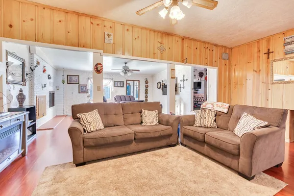 a living room with furniture a refrigerator and a window