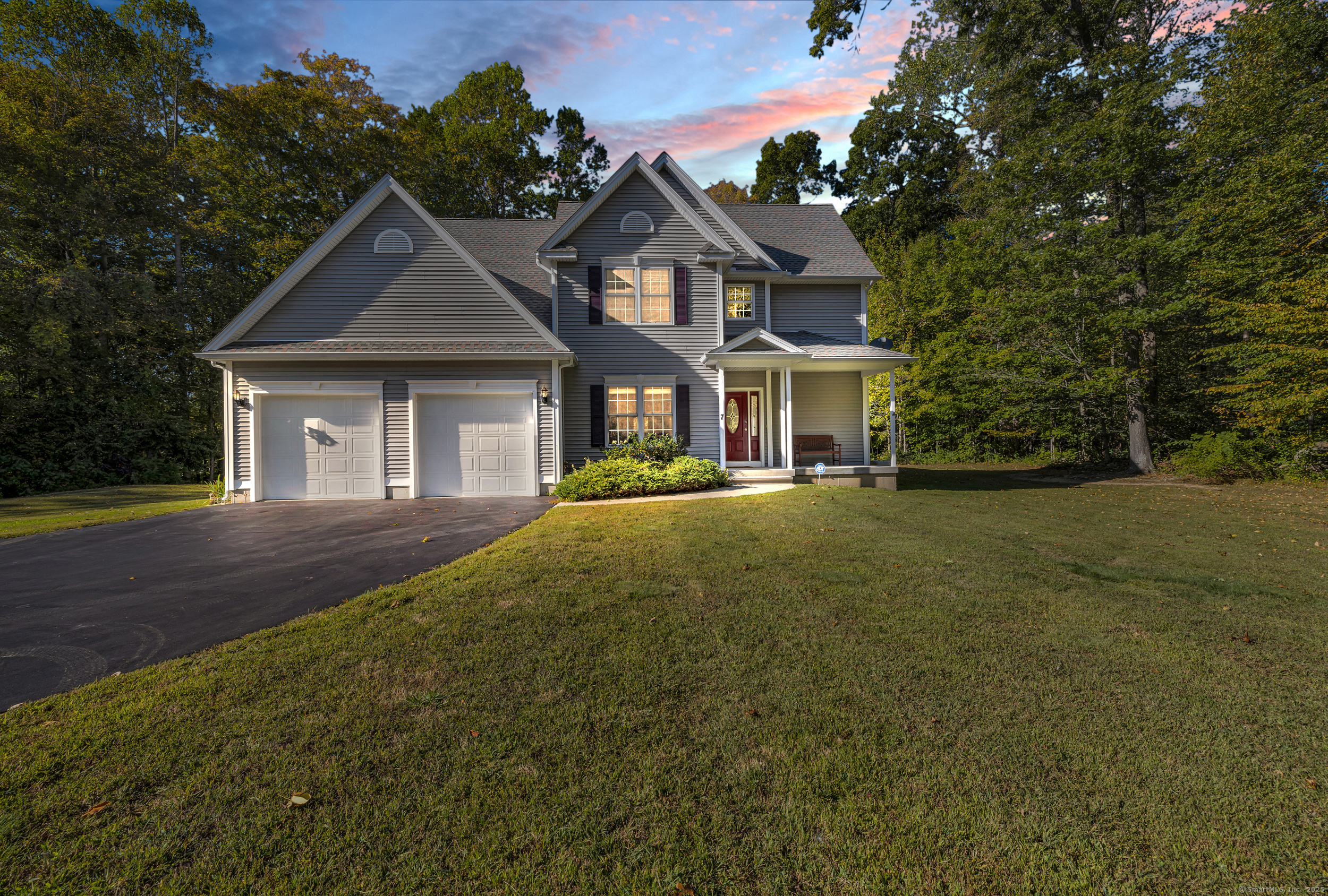 a front view of a house with yard and green space