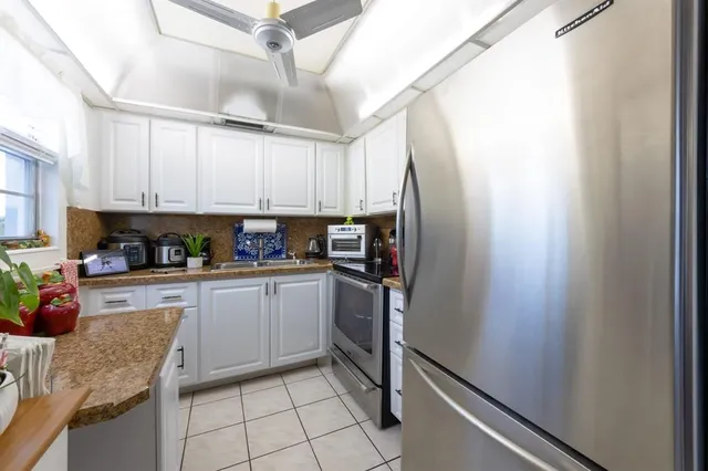 a kitchen with stainless steel appliances granite countertop a refrigerator sink and cabinets