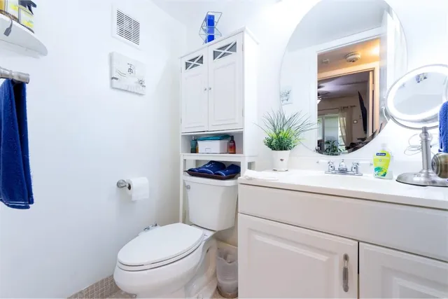 a bathroom with a sink mirror vanity and toilet