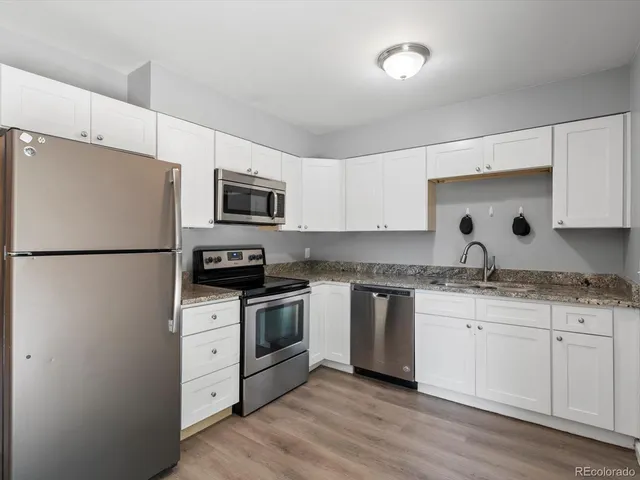 a kitchen with appliances a sink and cabinets