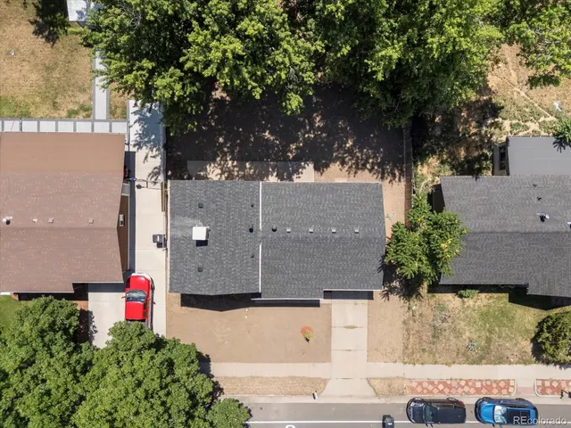 an aerial view of a house with a yard and large tree