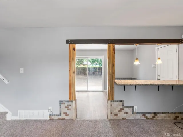 a kitchen with granite countertop a refrigerator and a stove top oven