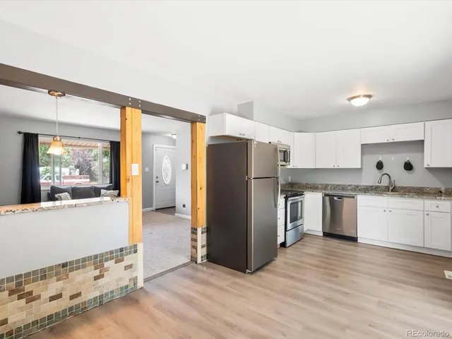 a kitchen with granite countertop a sink stove and refrigerator