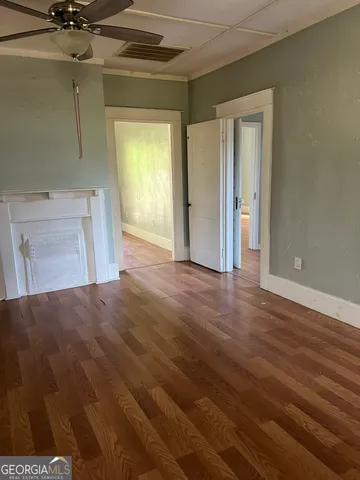 a view of a room with wooden floor and a bathroom