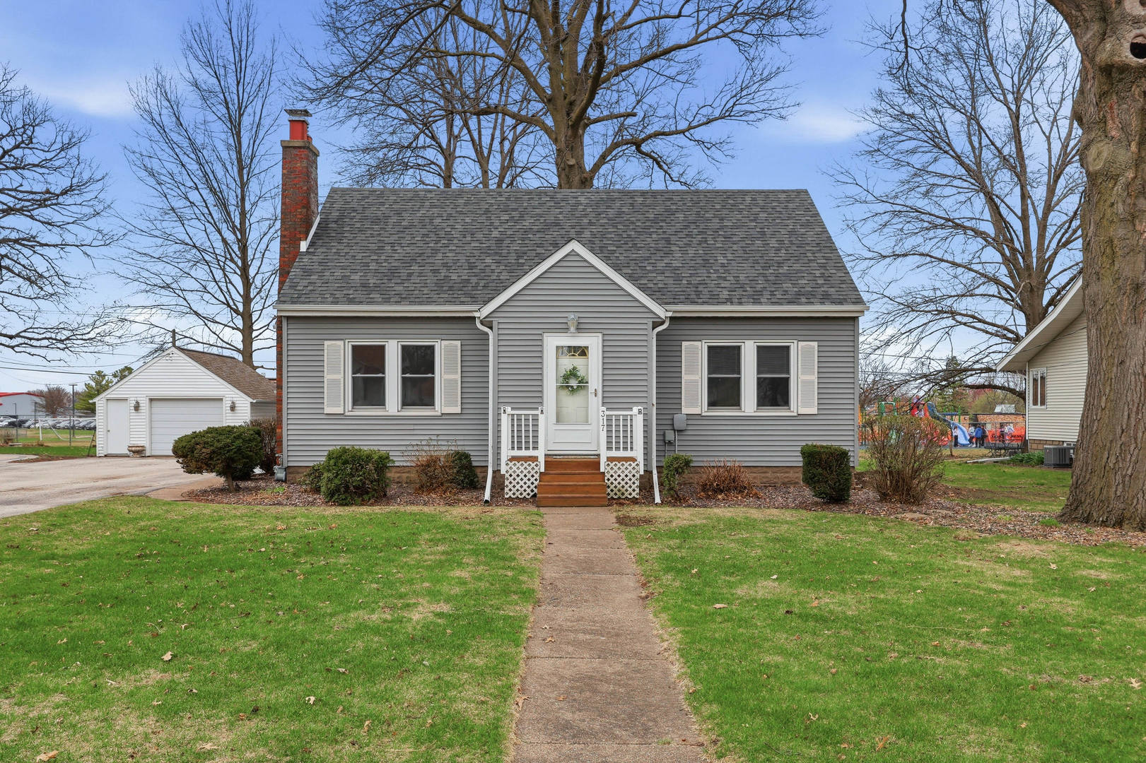 a front view of a house with a yard and trees
