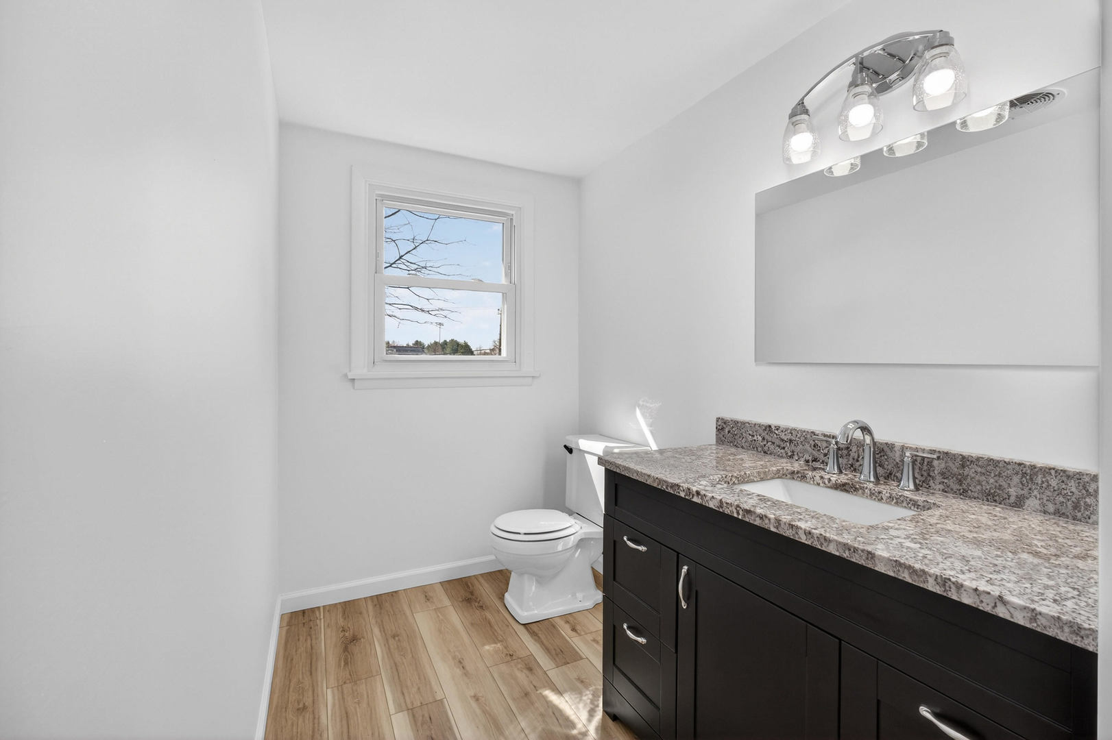 317 West Le Claire Road Eldridge, IA 52748 - Photo 24 of 43 a bathroom with a granite countertop sink a toilet and a mirror