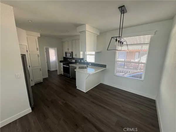 a kitchen with stainless steel appliances a refrigerator stove and wooden floor