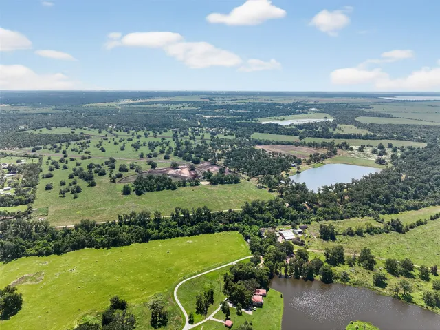 an aerial view of a city with lots of residential buildings and ocean view in back