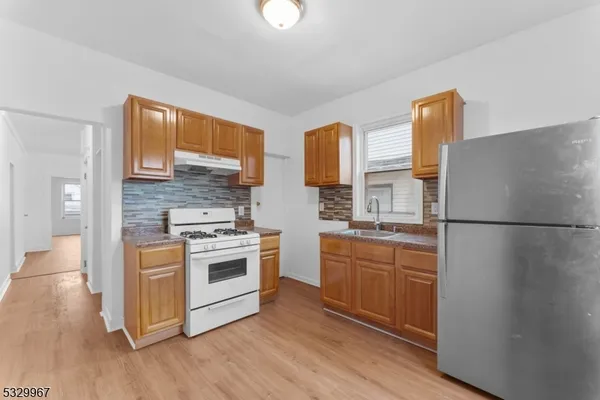 a kitchen with a stove a sink and a refrigerator