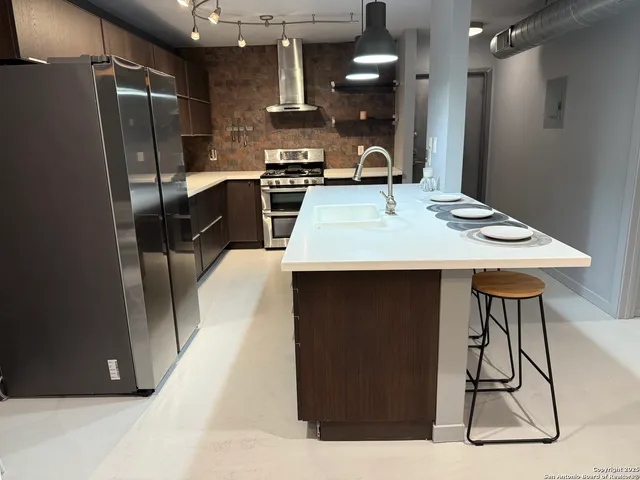 a kitchen with a sink a refrigerator and cabinets