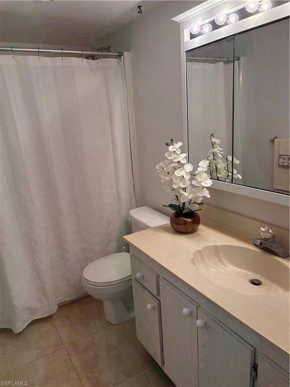 315 St Andrews Boulevard, Unit A2 Naples, FL 34113 - Photo 17 of 17 Full bath featuring vanity, curtained shower, and light tile patterned floors