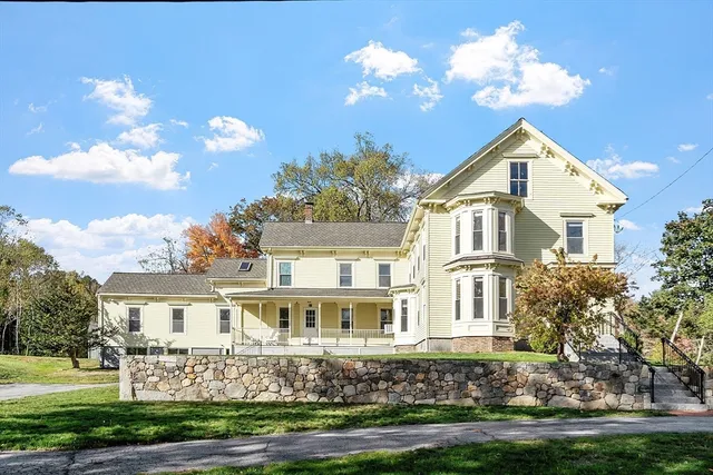 a front view of a house with a yard and trees