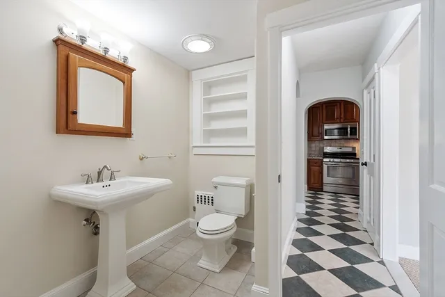 a bathroom with a sink a toilet and a mirror