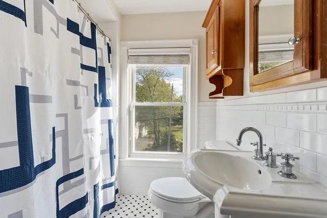 a bathroom with a sink toilet and a mirror