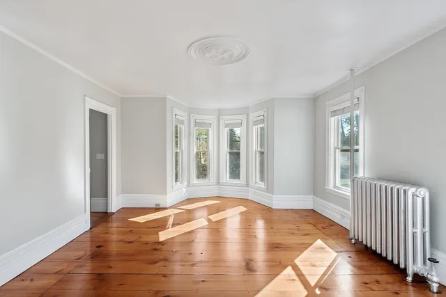 a view of a livingroom with wooden floor and a window