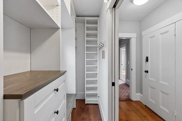a view of kitchen with hallway and wooden floor