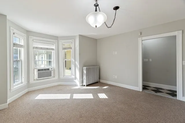 a view of a livingroom with a large window and chandelier
