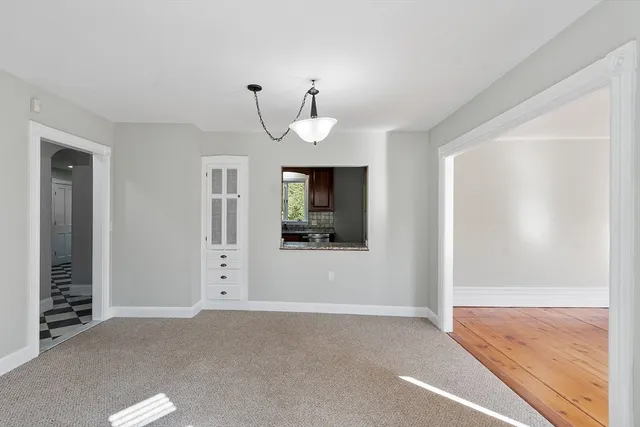 a view of a livingroom with a chandelier fan and windows