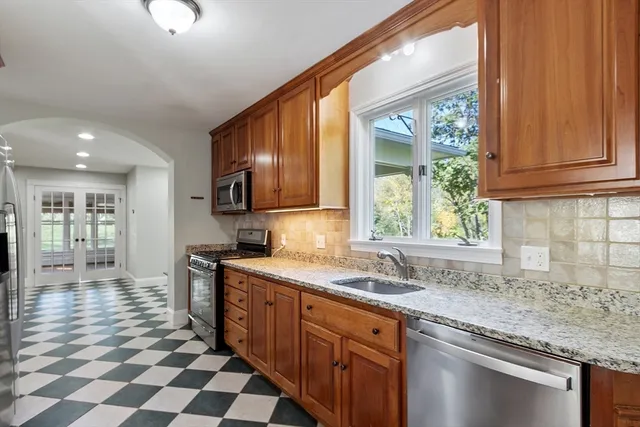 a kitchen with stainless steel appliances granite countertop a sink stove and cabinets