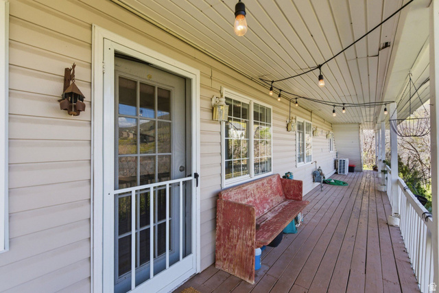 380 Luzern Road Midway, UT 84049 - Photo 34 of 74 Expansive covered porch featuring wood-finish decking, horizontal siding, multiple windows, and a glass-paneled screen door