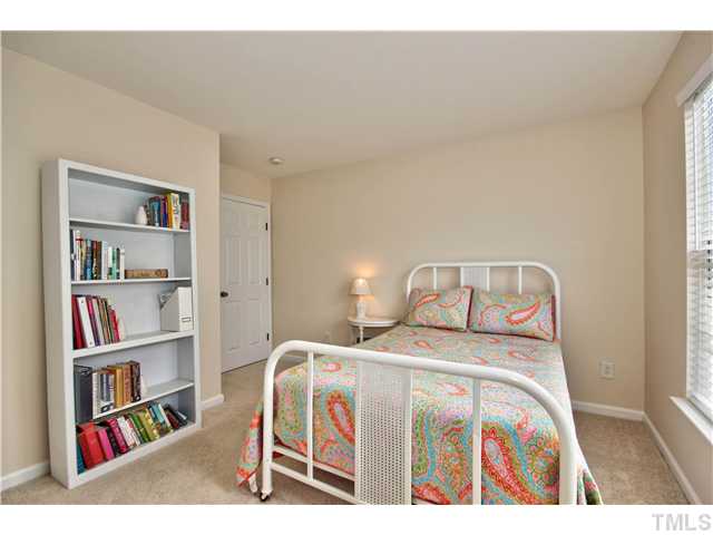 9827 Layla Avenue Raleigh, NC 27617 - Photo 18 of 20 a bedroom with a bed and book shelf